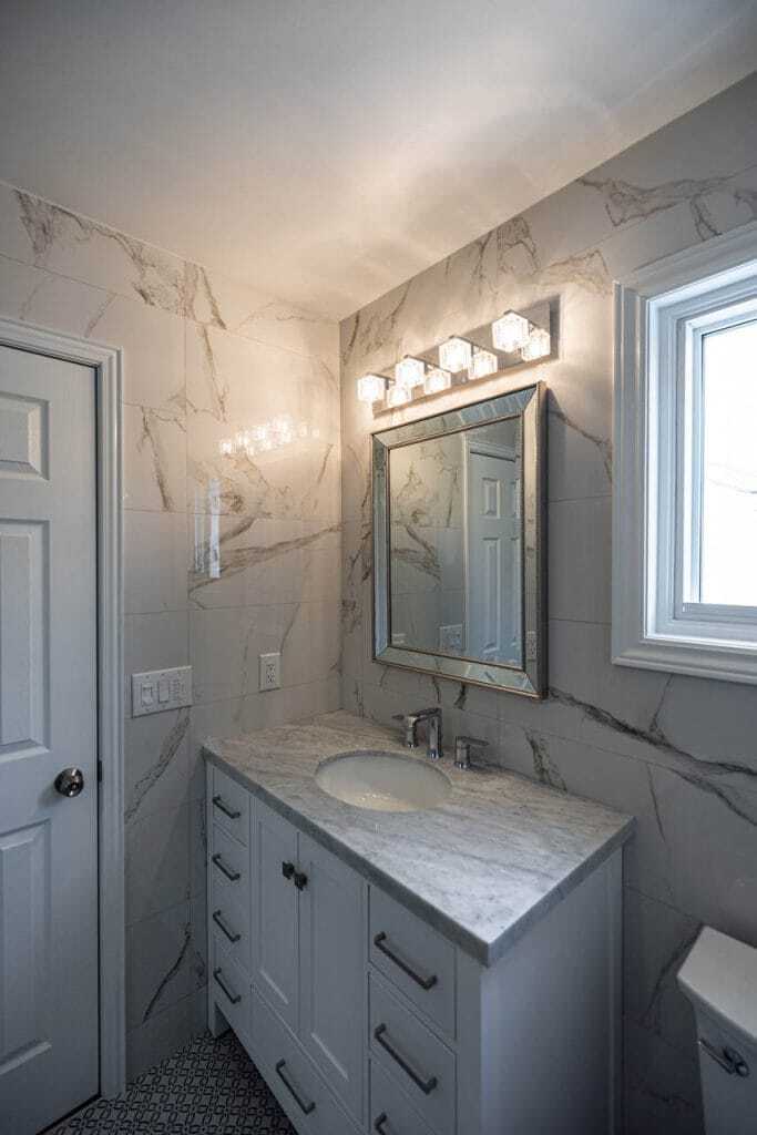white vanity with large tiles on wall renovation