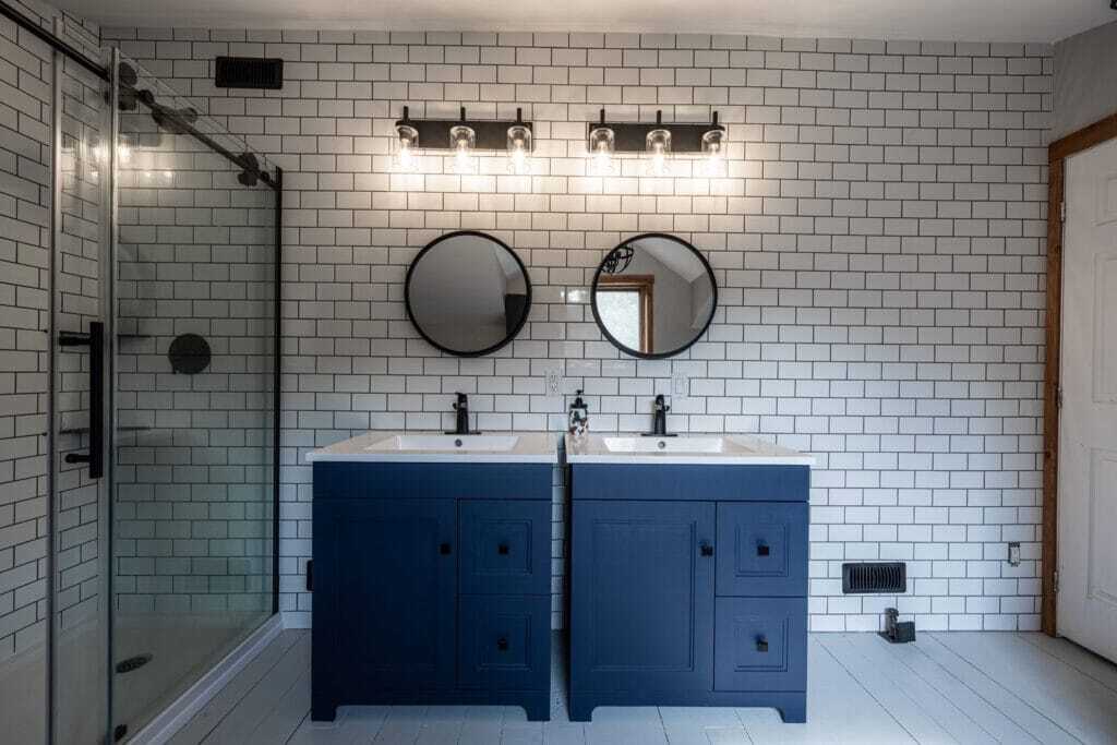 cabinet vanity with ceramic countertop and round mirrors