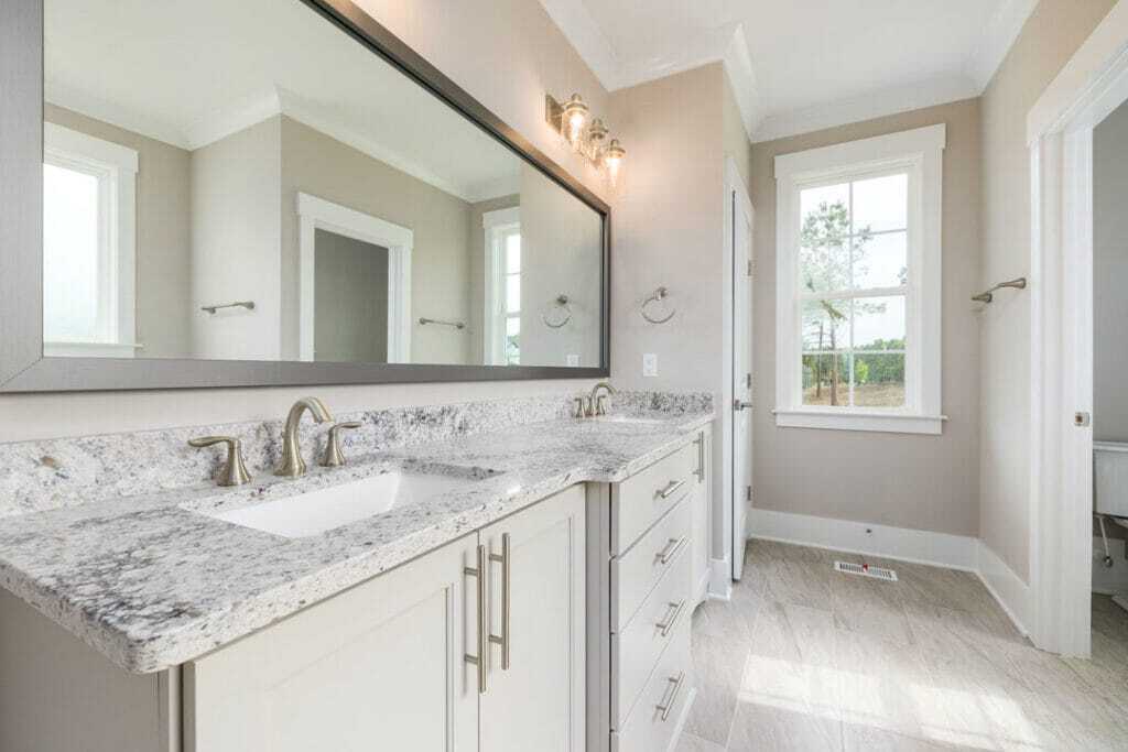 large vanity with marble countertop and vinyl flooring
