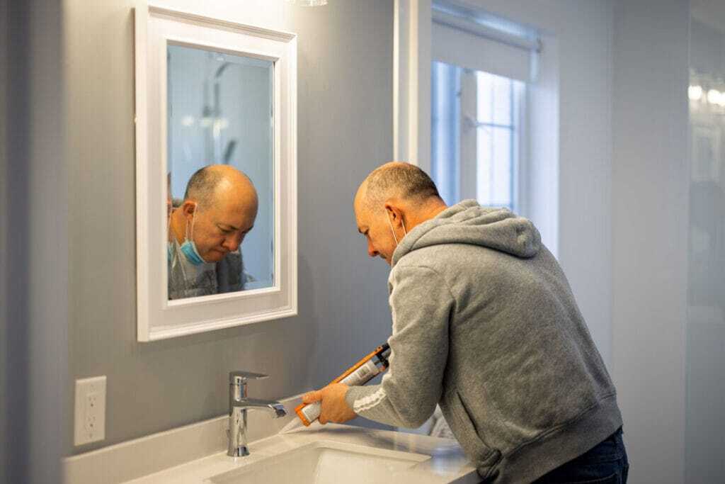 iBathrooms contractor Oleg applying silicone