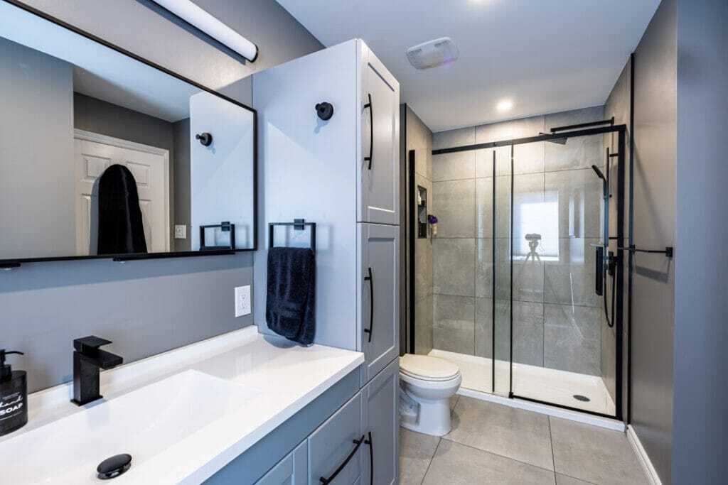 grey and black themed modern bathroom including shower room with vanity and toilet