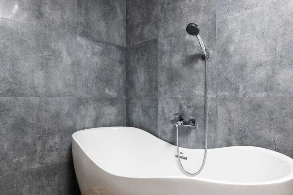 natural stone large tiled wall with free standing bath tub